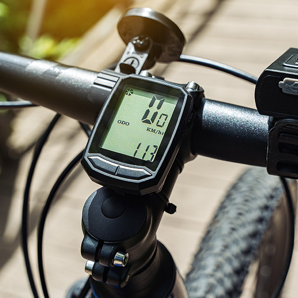 Das Bild zeigt einen Fahrradcomputer, der an einem Fahrradlenker montiert ist und eine Geschwindigkeit von 0 km/h anzeigt.